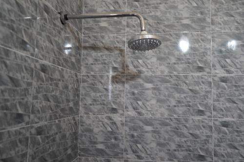 ducha con puerta de cristal y cabezal de ducha en Chez Imnir en Ijjoukak
