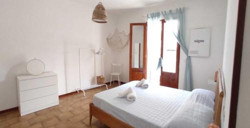 una camera da letto con un letto bianco e asciugamani di Case Vacanze Tropea La Pinnata a Tropea