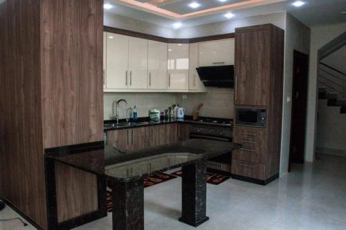 a kitchen with wooden cabinets and a black counter top at Alhussam Villa & Chalet - Dead Sea in Al Rama