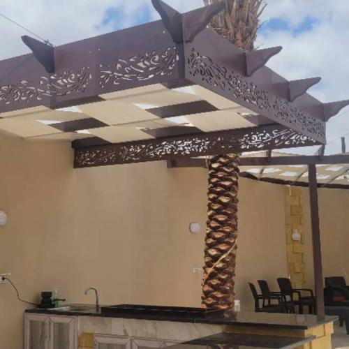 a patio with an umbrella and a table and chairs at Alhussam Villa & Chalet - Dead Sea in Al Rama