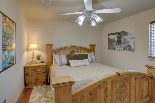 Un dormitorio con una cama de madera y un ventilador de techo. en Waterfront Granbury House with Deck and Private Dock!, en Granbury