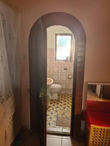 an archway leading to a bathroom with a toilet at Ponce Pension in Zsámbék