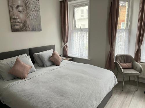 1 dormitorio con 1 cama, 1 silla y ventanas en Double four en Bournemouth