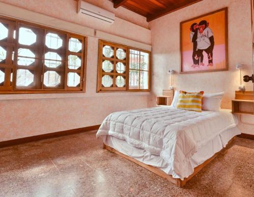 a bedroom with a large bed in a room with windows at Macarena Hostel in Flores