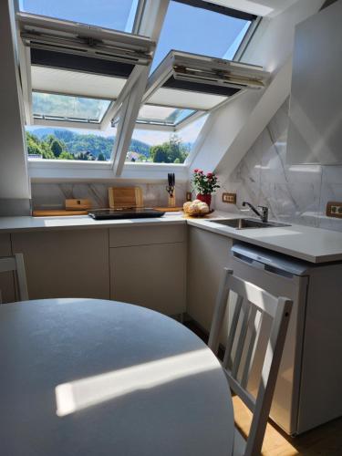a kitchen with a table and two skylights at Vila Rajska ptica in Bled