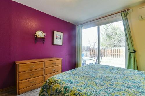 a bedroom with a purple wall with a bed and a dresser at Charming 2 Bedroom Near Downtown - Rose Tree 1 in Moab