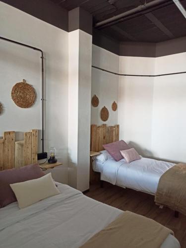 - une chambre avec 2 lits et un miroir dans l'établissement Albergue HR, à Sarria
