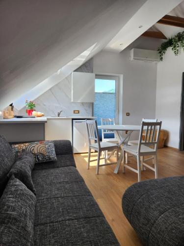 a living room with a couch and a table with chairs at Vila Rajska ptica in Bled