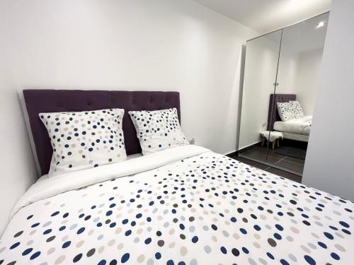 a bedroom with a large bed with polka dot pillows at Appartement élégant - 12min CDG in Dammartin-en-Goële