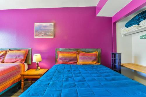 Habitación con 2 camas y pared púrpura. en Cozy Adventure Pad Near Downtown - Rose Tree 2 en Moab