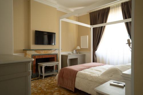 Habitación de hotel con cama y chimenea en Hotel Bellonda, en Forte dei Marmi