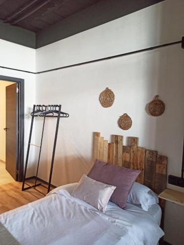 a bedroom with a bed with a wooden headboard at Albergue HR in Sarria