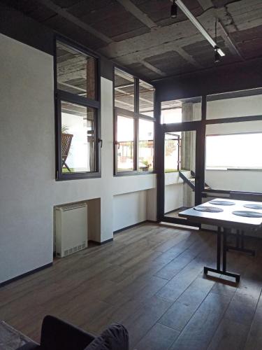 an empty room with a table and some windows at Albergue HR in Sarria