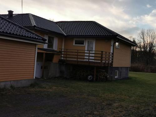 a house with a deck on the side of it at Spacious apartment on Kvaløya in Kvaloysletta