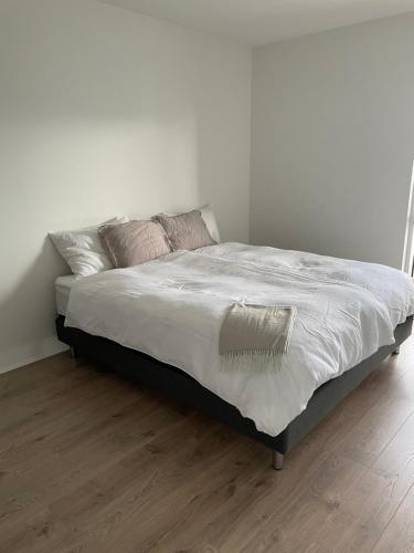 a bed with white sheets and pillows in a bedroom at Well located luxury apartment in Njarðvík
