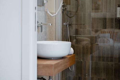 a bathroom with a white bowl sink on a wooden counter at Be Your Home - Riviera Suites in Civitavecchia