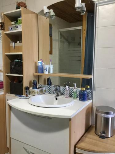 ein Bad mit einem Waschbecken und einem Spiegel in der Unterkunft Chez Lofred 1 in Four