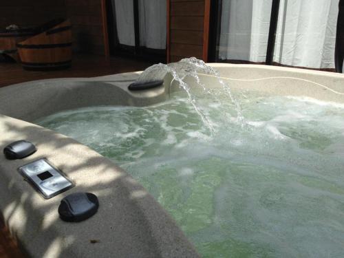 a jacuzzi tub with water pouring into it at Cabañas SPA Olmue in Olmué