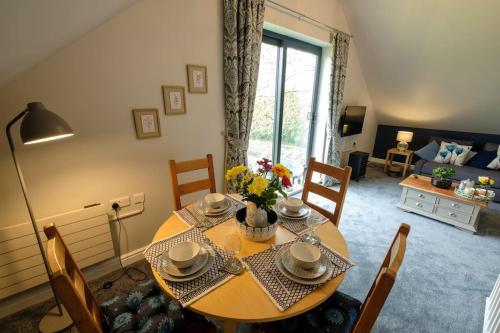 a dining table and chairs in a living room at Meadow Bank, fabulous apartment in Baddiley