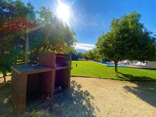 a wooden bench sitting in a park with the sun at Cabañas La Luz in Olmué