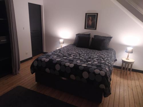 a bedroom with a large bed with two lamps at DS Harmothe in Chamouille