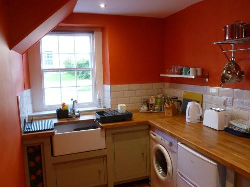 a kitchen with a sink and a washing machine at The Coach House, Hesket Newmarket in Hesket Newmarket