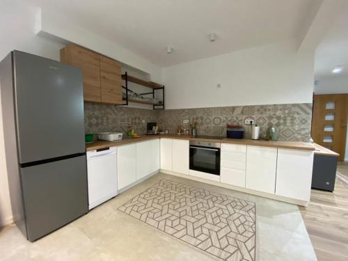 a kitchen with white cabinets and a refrigerator at Villa Rivus in Sarajevo