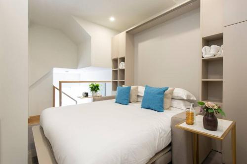 a bedroom with a large white bed with blue pillows at City Life Bliss Central Studio in Reading CHRL F3 in Reading