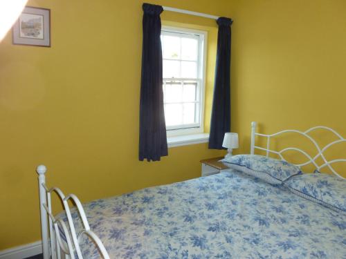 a bedroom with a bed and a window at The Coach House, Hesket Newmarket in Hesket Newmarket