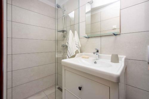 a white bathroom with a sink and a shower at Apartment in Selce 5803 in Selce
