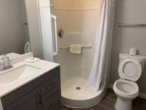 a bathroom with a shower and a toilet and a sink at Loyalty Inn Columbus in Brice