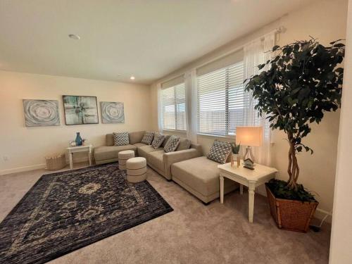 a living room with a couch and a potted plant at Brand-New, Beautiful & Stylish Home in Sacramento! in Sacramento