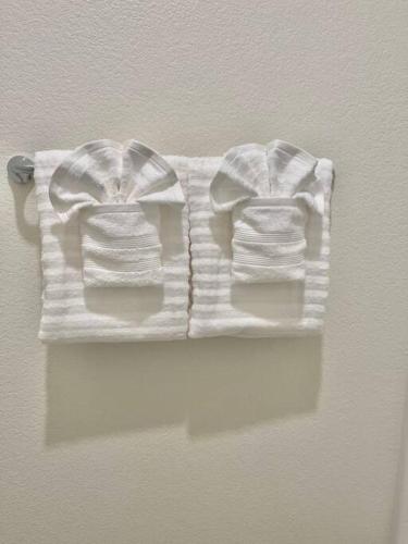 two white sweaters are hanging on a wall at Brand-New, Beautiful & Stylish Home in Sacramento! in Sacramento