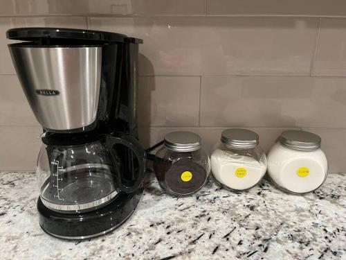 a blender and three jars on a counter at Brand-New, Beautiful & Stylish Home in Sacramento! in Sacramento