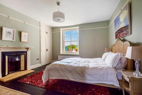 a bedroom with a bed and a fireplace at Church view apartment in Drewsteignton