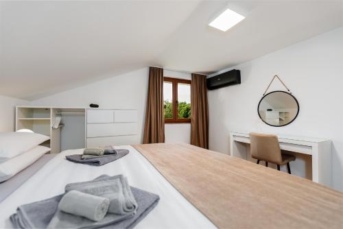 a bedroom with a bed with a desk and a mirror at Villa Trn in Cetingrad