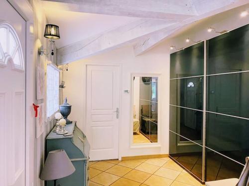 a hallway with a glass shower and a table with a lamp at Maison 120m² à 400 m de la plage in La Londe-les-Maures