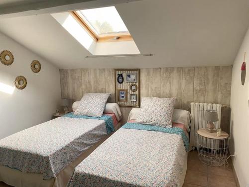 a bedroom with two beds and a skylight at Maison 120m² à 400 m de la plage in La Londe-les-Maures