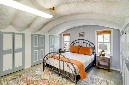 a bedroom with a bed with an orange comforter at Charming Bay St Louis Home Deck, on Canal! in Shoreline Park