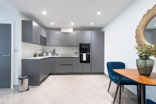 a kitchen with gray cabinets and a wooden table at Urban Chic Central Studio in Reading Centre CHRL F7 in Reading