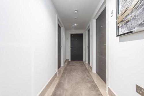 a hallway with white walls and a black door at Urban Chic Central Studio in Reading Centre CHRL F7 in Reading