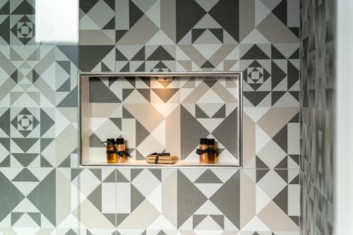 a room with a mirror and a geometric wall at Suite Mariagiovanni in Lecce