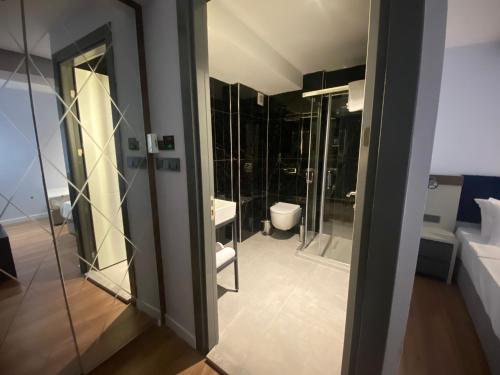 y baño con aseo, lavabo y espejos. en THE ROYALS HOTEL en İzmir