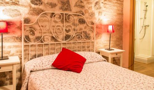 ein Schlafzimmer mit einem Bett mit einem roten Kissen darauf in der Unterkunft Casa de Gaitán in Toledo