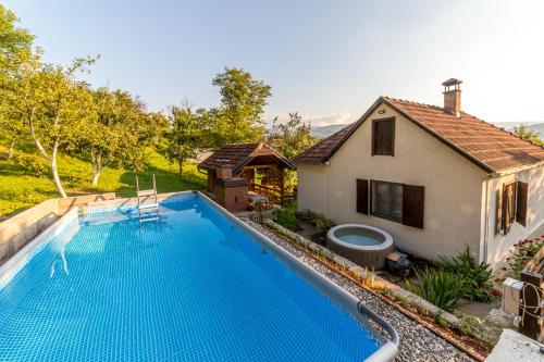 una villa con piscina accanto a una casa di Rustična kuća CRVENA STENA u blizini kućice na Drini a Bajina Bašta