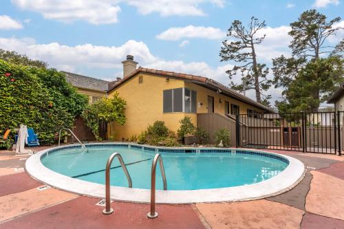 a swimming pool in front of a house at Best Western Carmel's Town House Lodge in Carmel