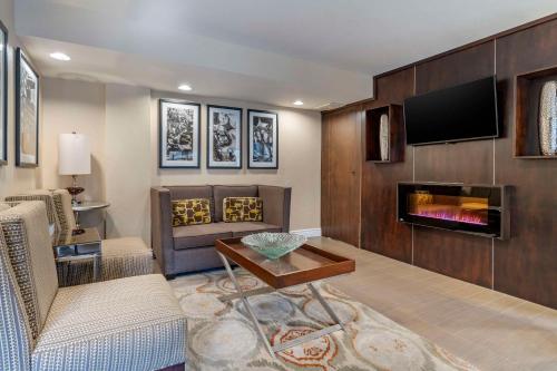 a living room with a fireplace and a tv at Best Western Carmel's Town House Lodge in Carmel