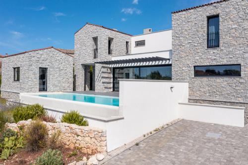 a stone house with a swimming pool at Cà Veia in Vrbnik
