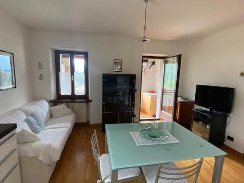 a living room with a table and a couch at Il tuo nido sulle Dolomiti, con vista panoramica! in Calalzo