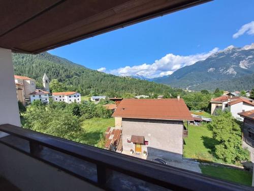 een uitzicht vanuit een raam van een stad met een berg bij Il tuo nido sulle Dolomiti, con vista panoramica! in Calalzo